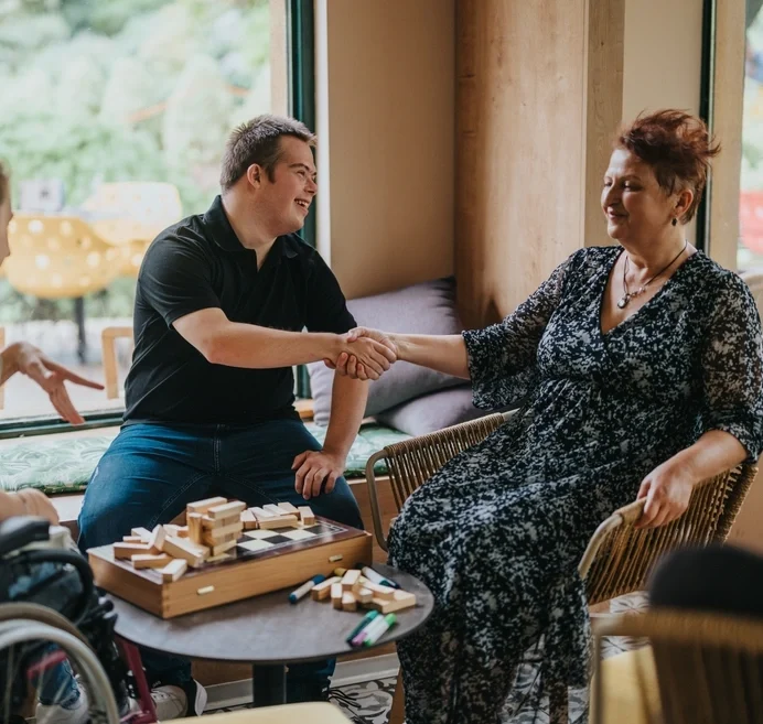Support worker and disabled man shaking hands